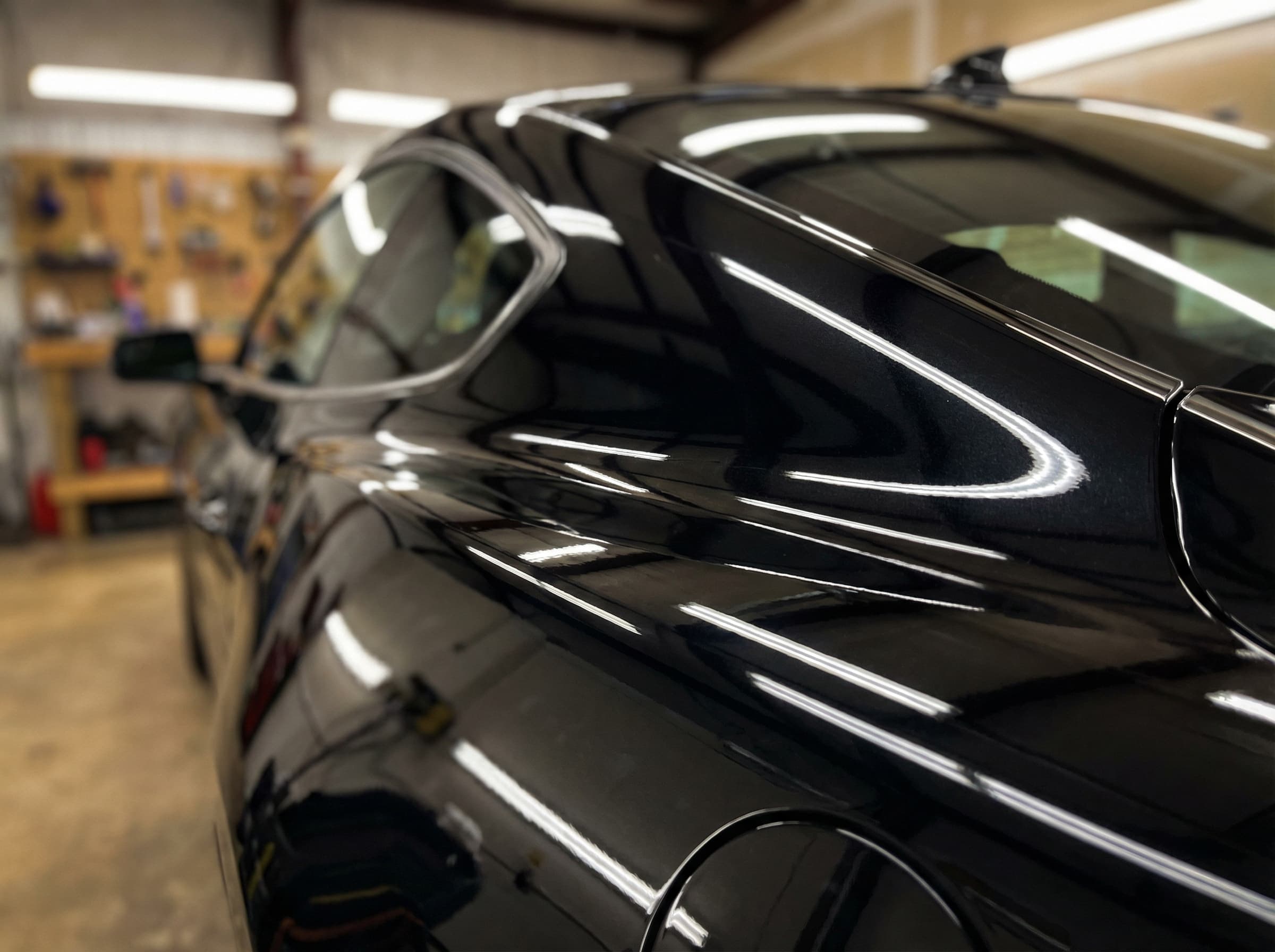 Deep mirror-like gloss on a black ceramic coated car panel